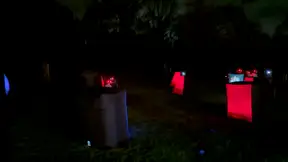 Glowing inflatable laser tag bunkers set up for a backyard 14th birthday party at night